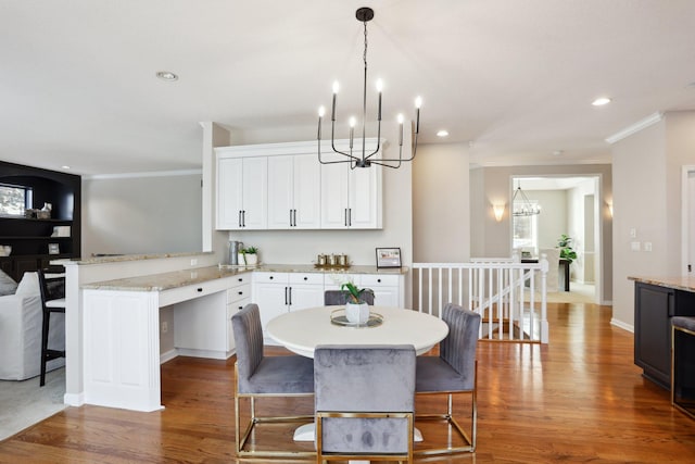 dining room featuring a notable chandelier, hardwood / wood-style flooring, and ornamental molding