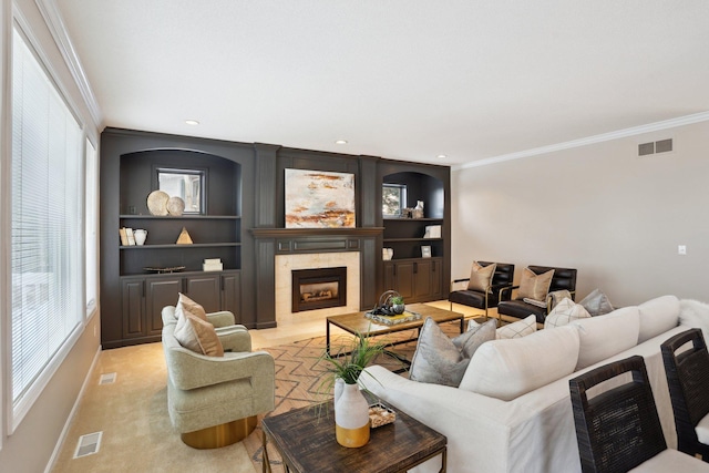 living room featuring crown molding, light carpet, built in features, and a fireplace