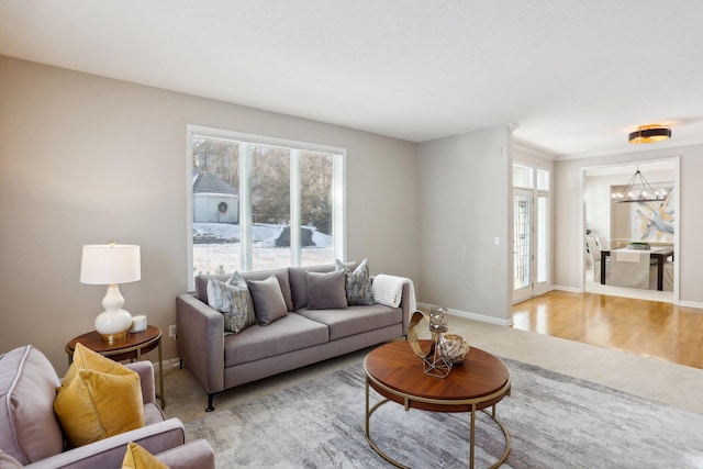 living room with a wealth of natural light, light hardwood / wood-style floors, and a chandelier