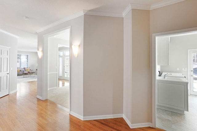 hall featuring crown molding, sink, and light hardwood / wood-style flooring