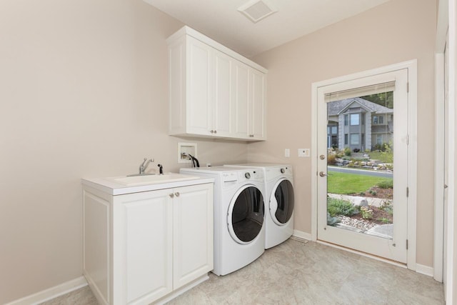 washroom with washer and dryer, sink, and cabinets