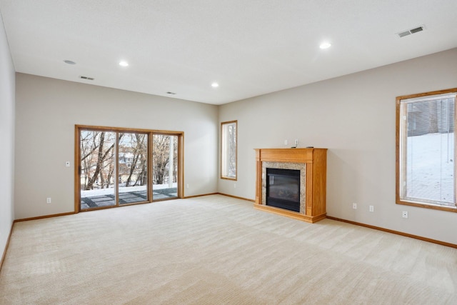 unfurnished living room with light carpet and a fireplace