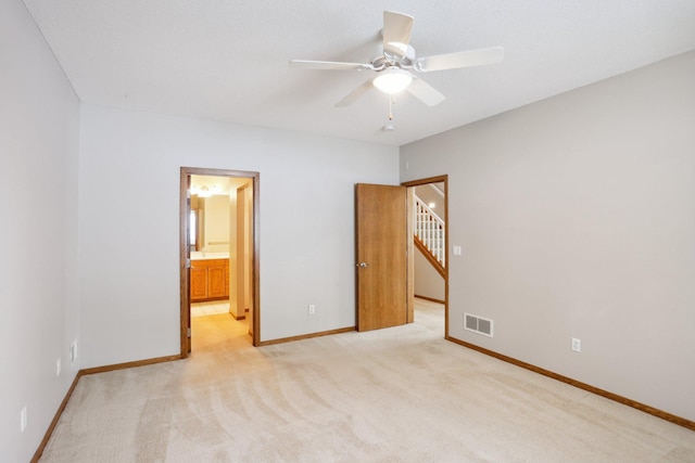 unfurnished bedroom with light carpet, ceiling fan, and ensuite bath