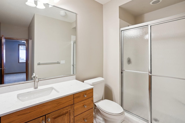 bathroom featuring vanity, an enclosed shower, and toilet