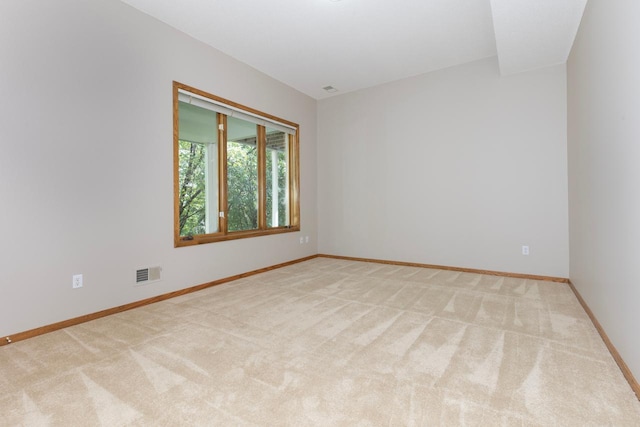 spare room featuring light colored carpet