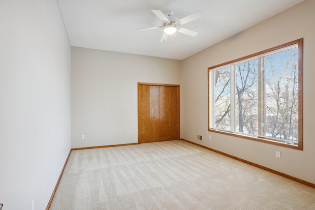 unfurnished bedroom with light colored carpet, a closet, and ceiling fan