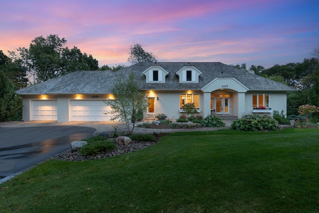 view of front of property featuring a garage and a lawn