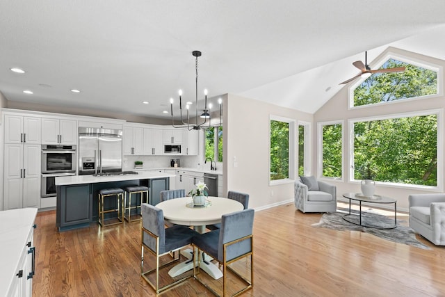 6229 Morningside Cir, Eden Prairie, MN 55344 - dining room with wood finished floors, lofted ceiling, ceiling fan, a chandelier, and recessed lighting