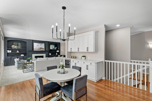 6229 Morningside Cir, Eden Prairie, MN 55344 - dining room featuring light wood-style floors, a chandelier, wine cooler, recessed lighting, and a fireplace