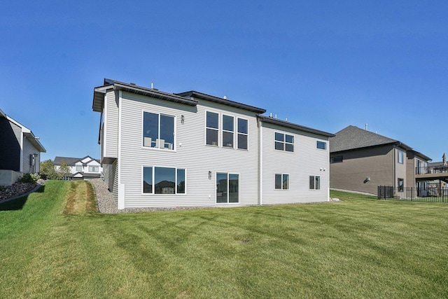 rear view of property with a yard and central air condition unit