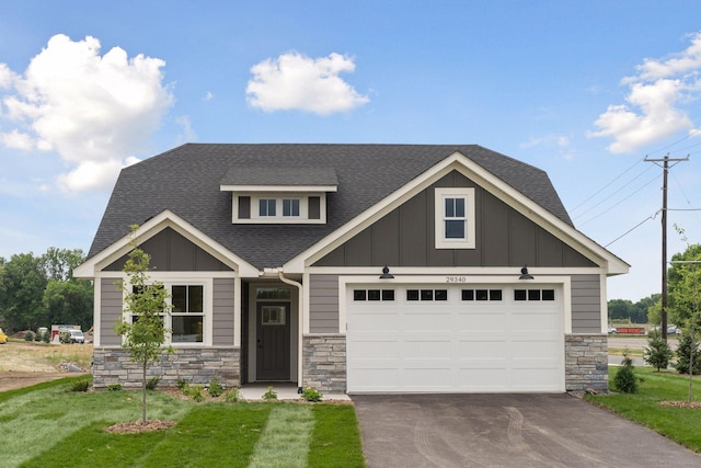 craftsman-style home featuring driveway, board and batten siding, and roof with shingles