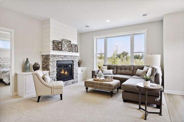 living area featuring a fireplace, baseboards, and recessed lighting