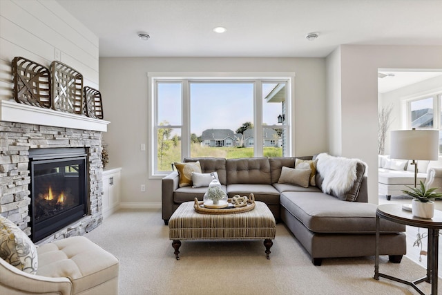 living area with light carpet, a fireplace, and baseboards