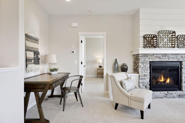 office with baseboards, a fireplace, and light colored carpet