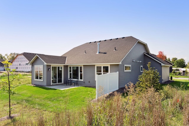 back of house featuring a patio area, a yard, and roof with shingles