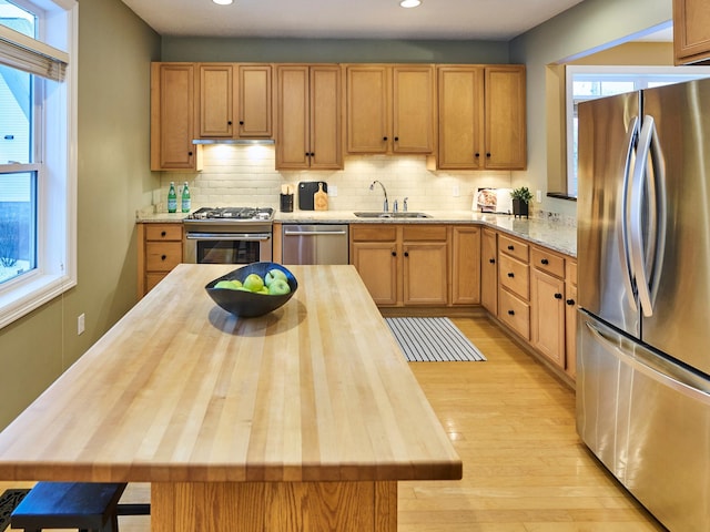 kitchen featuring stainless steel appliances, sink, wooden counters, and plenty of natural light