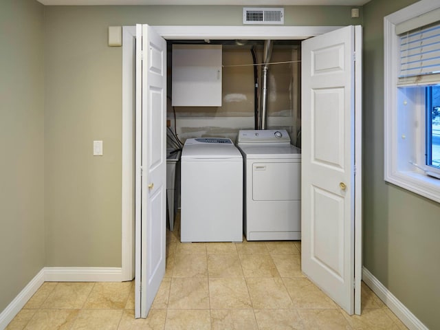 clothes washing area featuring light tile patterned floors and washing machine and clothes dryer