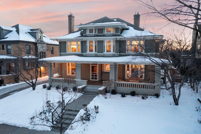 view of front of property featuring a chimney and a porch