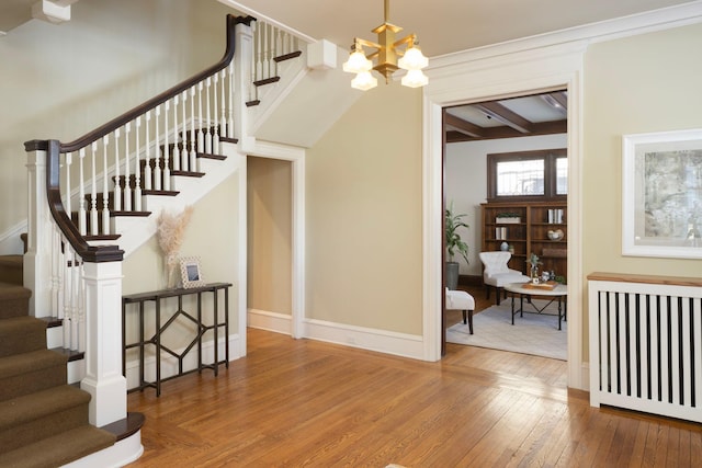 stairway featuring baseboards, a chandelier, wood finished floors, and beamed ceiling