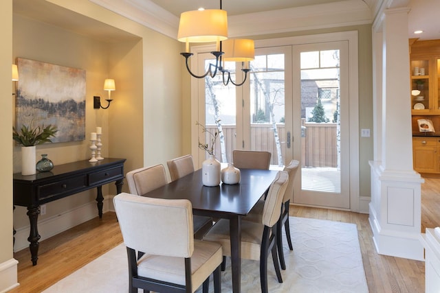 dining space featuring french doors, light wood-style floors, ornamental molding, a chandelier, and baseboards