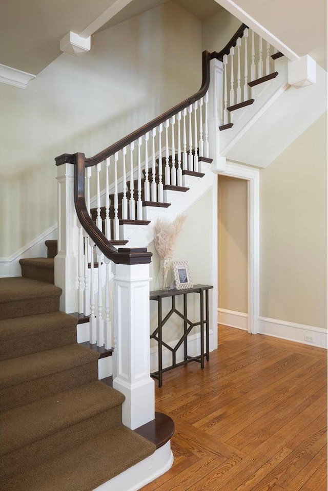 stairs featuring parquet floors and baseboards