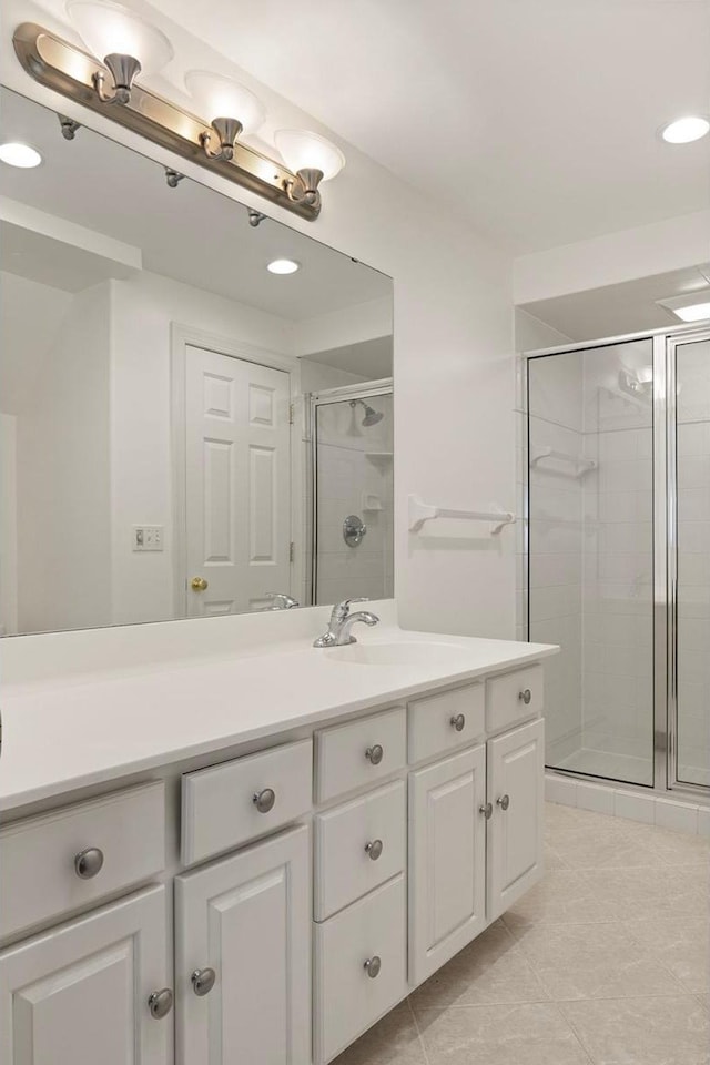 bathroom with tile patterned floors, a shower stall, and vanity