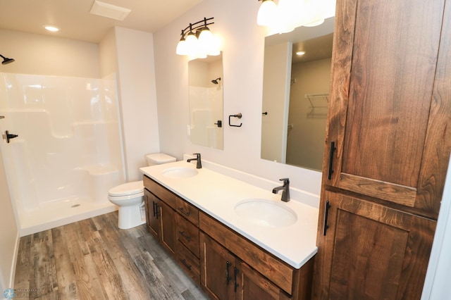 bathroom with vanity, walk in shower, toilet, and hardwood / wood-style floors