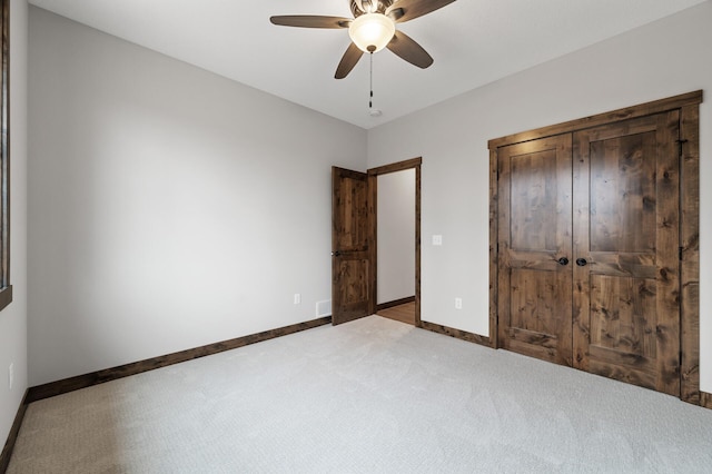 unfurnished bedroom with a closet, ceiling fan, and carpet flooring