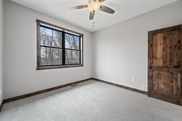 empty room with ceiling fan and light colored carpet