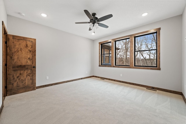 spare room featuring light carpet and ceiling fan