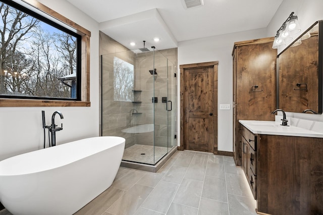 bathroom featuring vanity and independent shower and bath