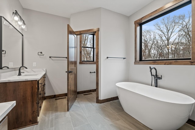 bathroom featuring tile patterned floors, vanity, and a bath