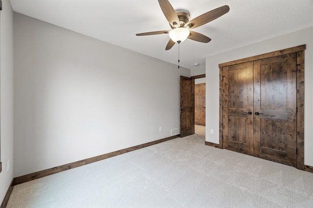 unfurnished bedroom with ceiling fan, carpet flooring, and a closet