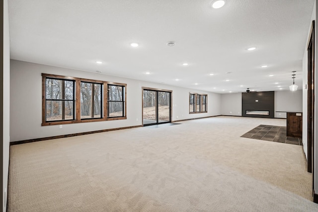 basement with light colored carpet and a large fireplace