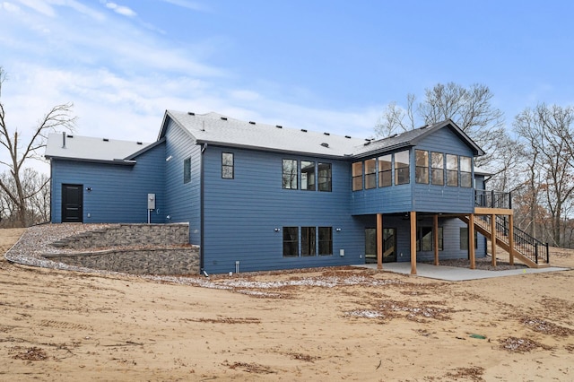 rear view of house featuring a sunroom and a patio