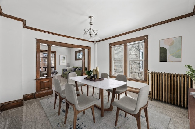 818 Sherburne Ave, Saint Paul, MN 55104 - dining space with radiator heating unit, ornamental molding, decorative columns, baseboards, and a chandelier