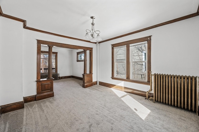 818 Sherburne Ave, Saint Paul, MN 55104 - spare room featuring radiator heating unit, crown molding, carpet flooring, ornate columns, and baseboards