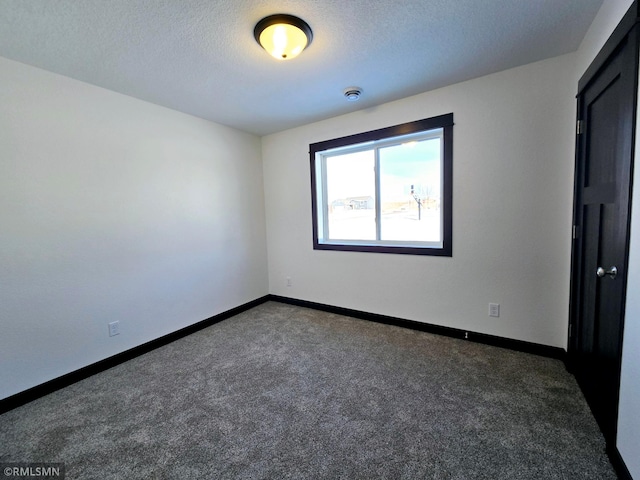 unfurnished bedroom featuring baseboards, dark colored carpet, and a textured ceiling