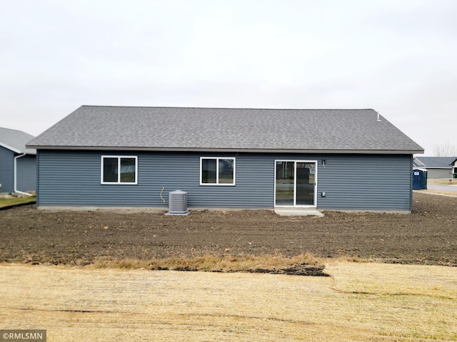 rear view of property with central AC and roof with shingles