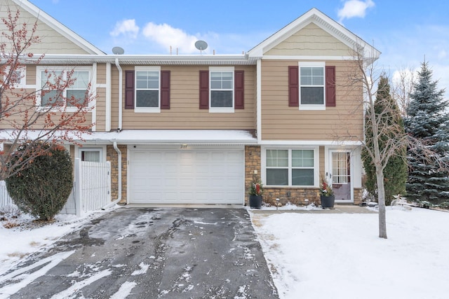 view of front of home featuring aphalt driveway, a garage, and stone siding