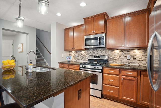 kitchen with decorative backsplash, brown cabinets, appliances with stainless steel finishes, and a sink