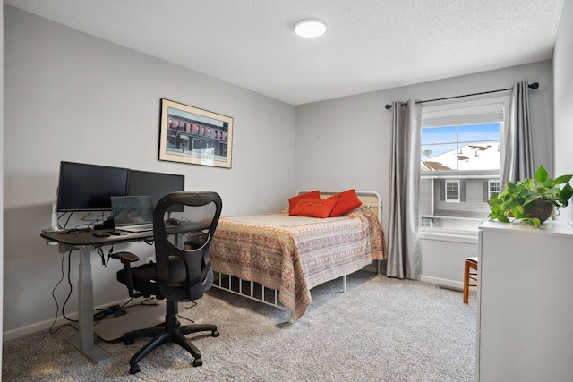 bedroom featuring carpet, baseboards, and a textured ceiling