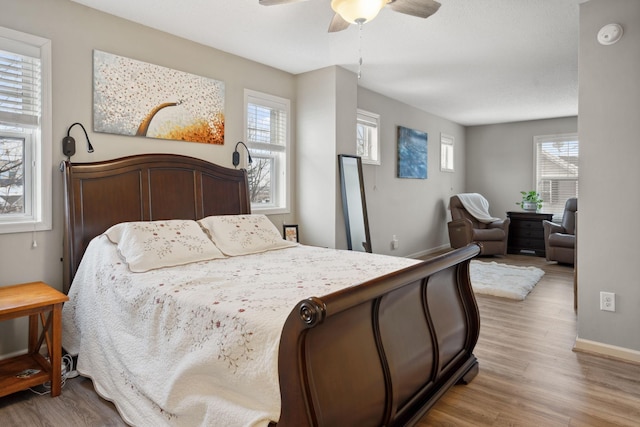 bedroom featuring wood finished floors, baseboards, and ceiling fan