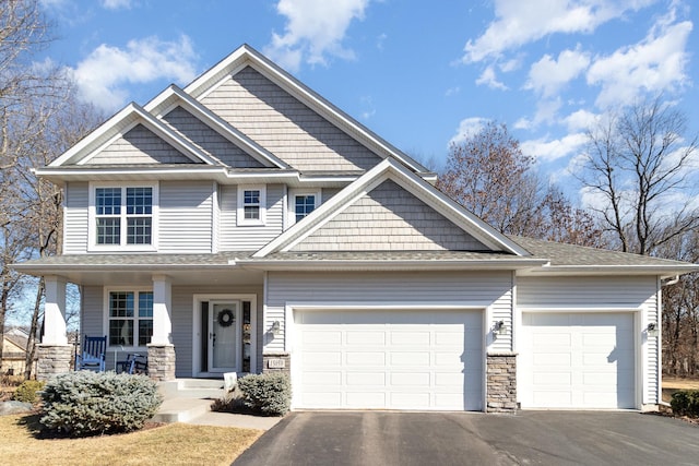 craftsman inspired home with aphalt driveway, a porch, a shingled roof, and an attached garage