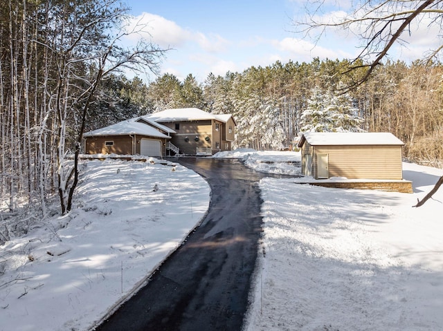 view of front of house featuring a shed, an outdoor structure, and a garage