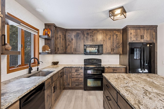 kitchen featuring light stone countertops, open shelves, a sink, black appliances, and backsplash