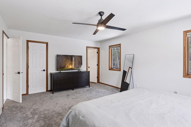 bedroom with ceiling fan, a textured ceiling, baseboards, and carpet floors