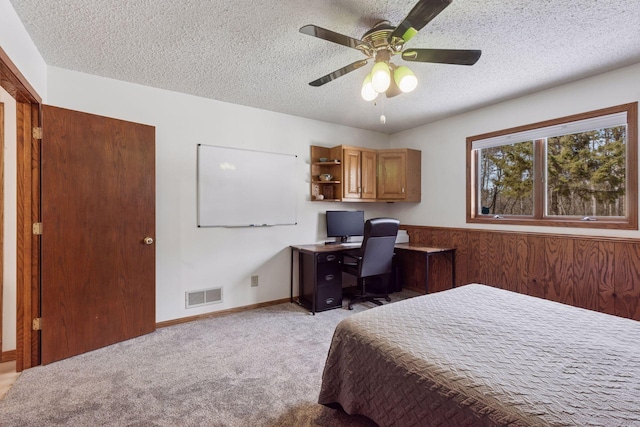 bedroom with visible vents, a ceiling fan, a textured ceiling, baseboards, and light colored carpet