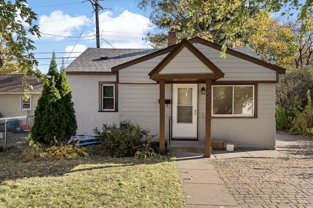 bungalow-style home with a patio and a front lawn