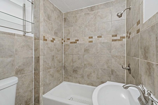 full bathroom featuring tiled shower / bath, sink, and toilet